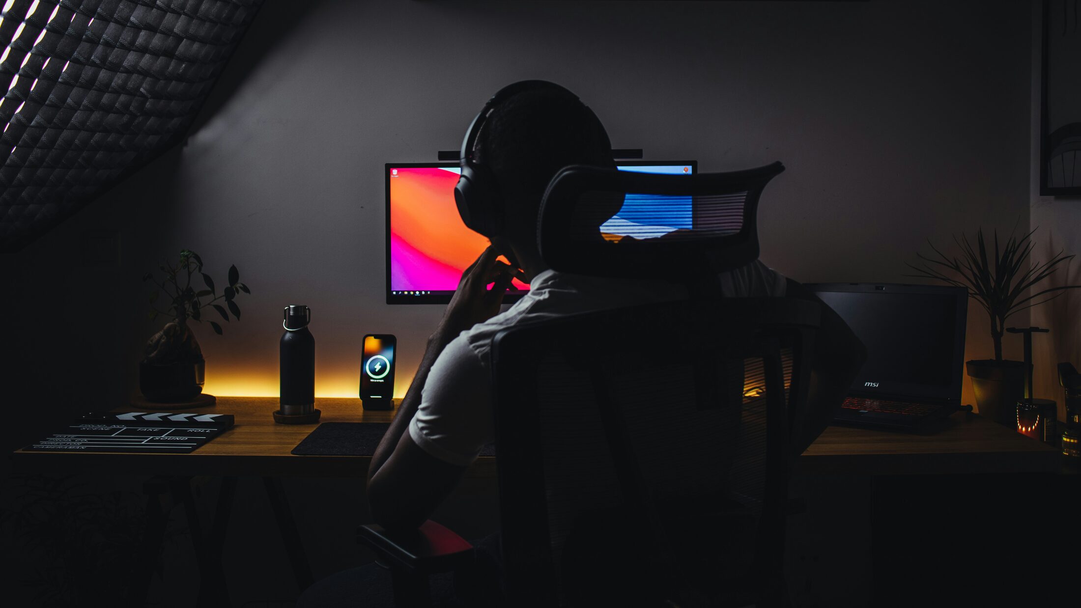 Creator at desk with headphones and monitors